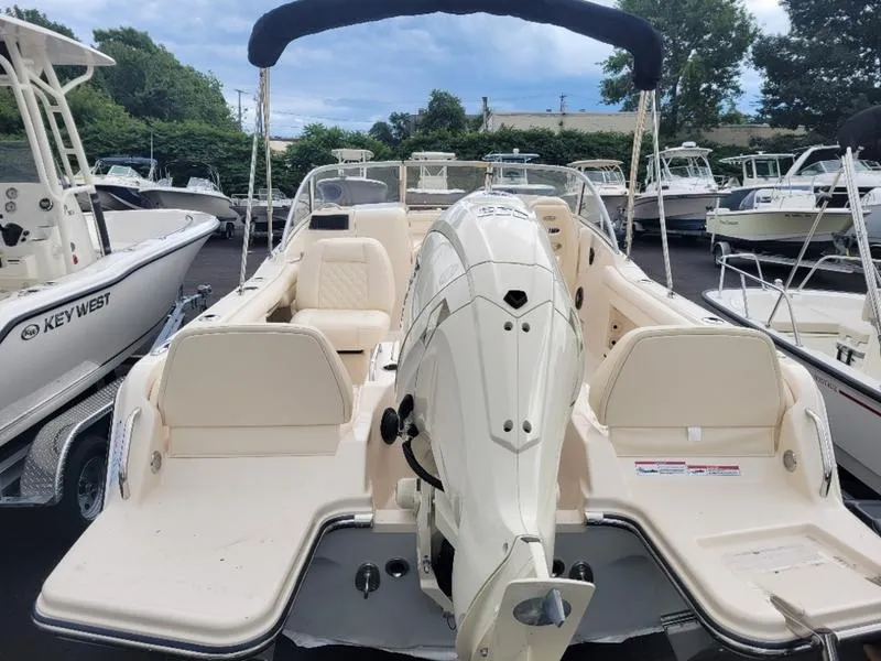 Slide: The Image of 2025 Grady-White Freedom 215 boat with outboard motor, docked among other boats. - 5