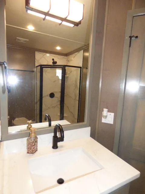 Slide: The Image of Modern bathroom in 2023 Sumerset 18x90 houseboat with glass shower and marble countertop. - 12
