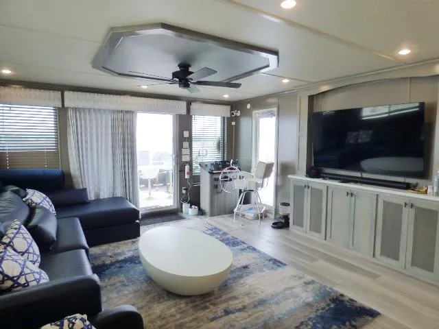 Slide: The Image of Modern living area in 2023 Sumerset 18x90 houseboat with large TV and stylish furniture. - 3
