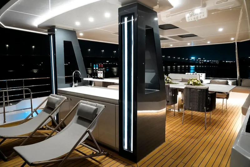 Slide: The Image of Luxurious 2024 Catamaran Diamond Yachts EF56 deck with modern seating and dining area at night. - 22