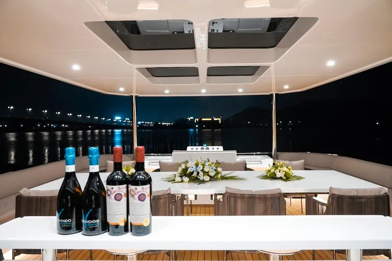 Slide: The Image of Luxurious 2024 Catamaran Diamond Yachts EF56 interior with wine bottles and floral arrangements at night. - 23