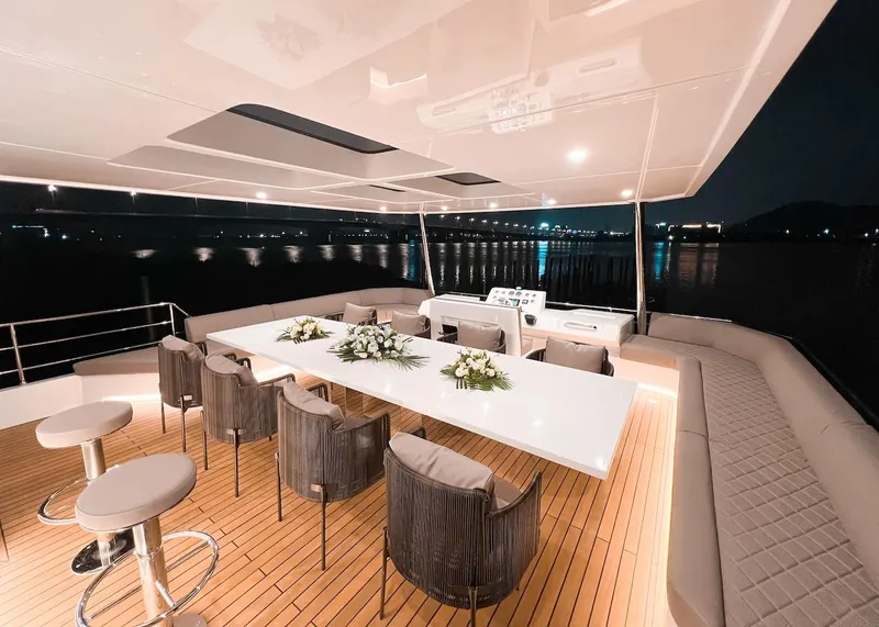 Slide: The Image of Luxurious 2024 Catamaran Diamond Yachts EF56 with elegant outdoor dining area at night. - 24
