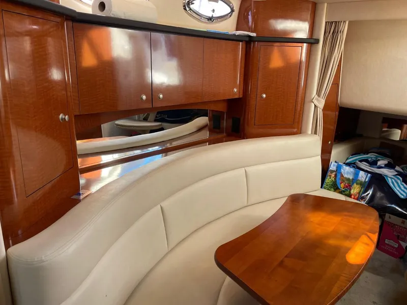 Slide: The Image of Interior of 2005 Sea Ray 320 Sundancer with wooden cabinets and curved seating area. - 11