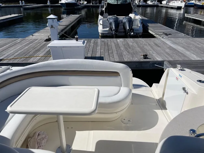 Slide: The Image of 2005 Sea Ray 320 Sundancer boat interior with seating and table at a marina. - 4