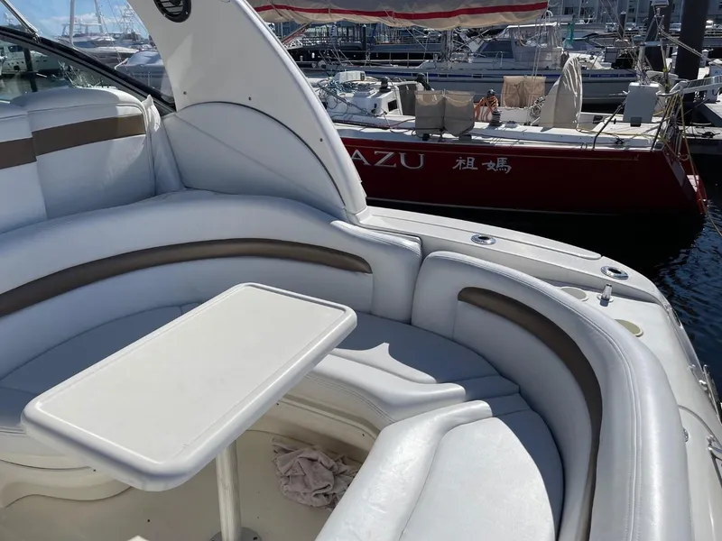 Slide: The Image of 2005 Sea Ray 320 Sundancer boat interior with seating and table, docked near other boats. - 5