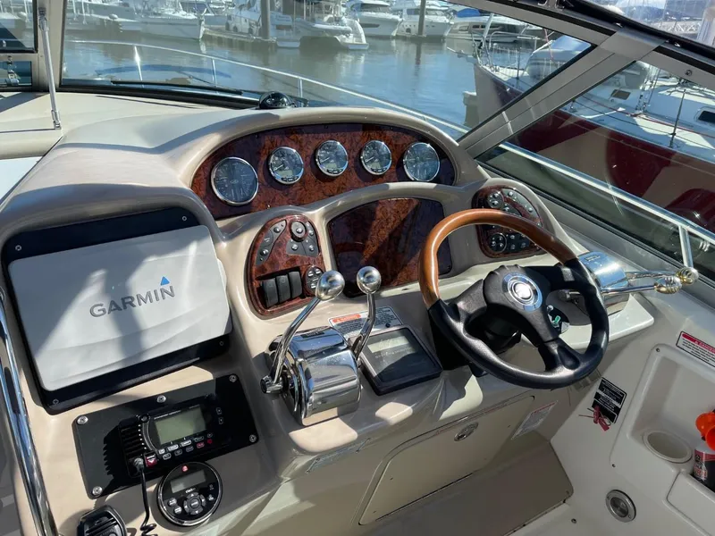 Slide: The Image of 2005 Sea Ray 320 Sundancer helm with Garmin navigation, wood accents, and modern controls. - 7