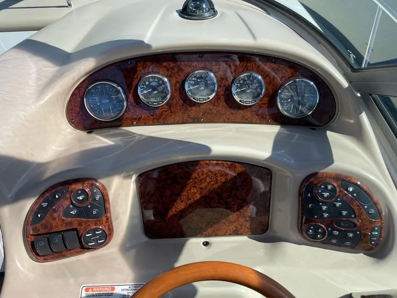 Slide: The Image of 2005 Sea Ray 320 Sundancer dashboard with wood accents and instrument gauges. - 9