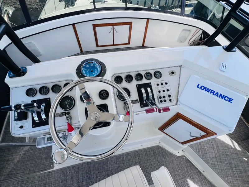 Slide: The Image of 1987 Carver 4227 Cockpit Motor Yacht helm with steering wheel and control panel. - 14