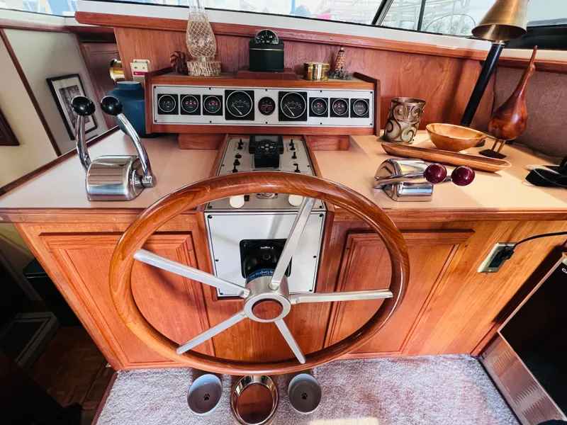 Slide: The Image of 1987 Carver 4227 Cockpit Motor Yacht helm with wooden steering wheel and control panel. - 18
