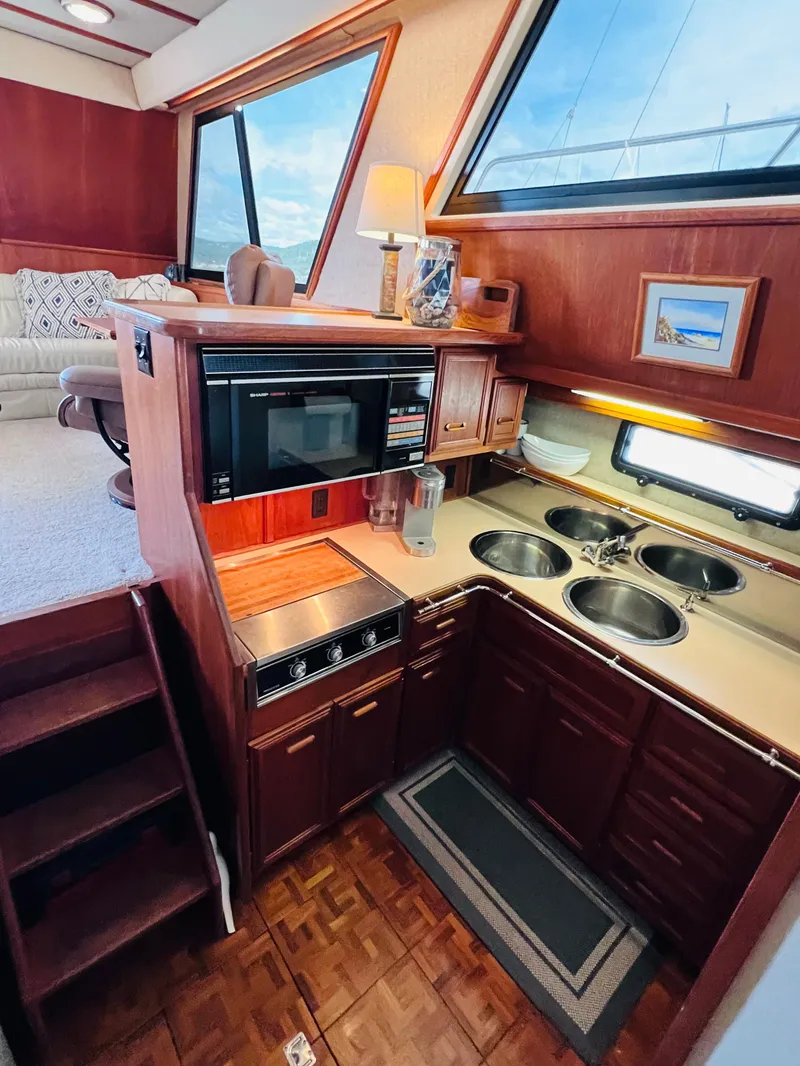Slide: The Image of 1987 Carver 4227 Cockpit Motor Yacht interior with kitchen and seating area. - 20