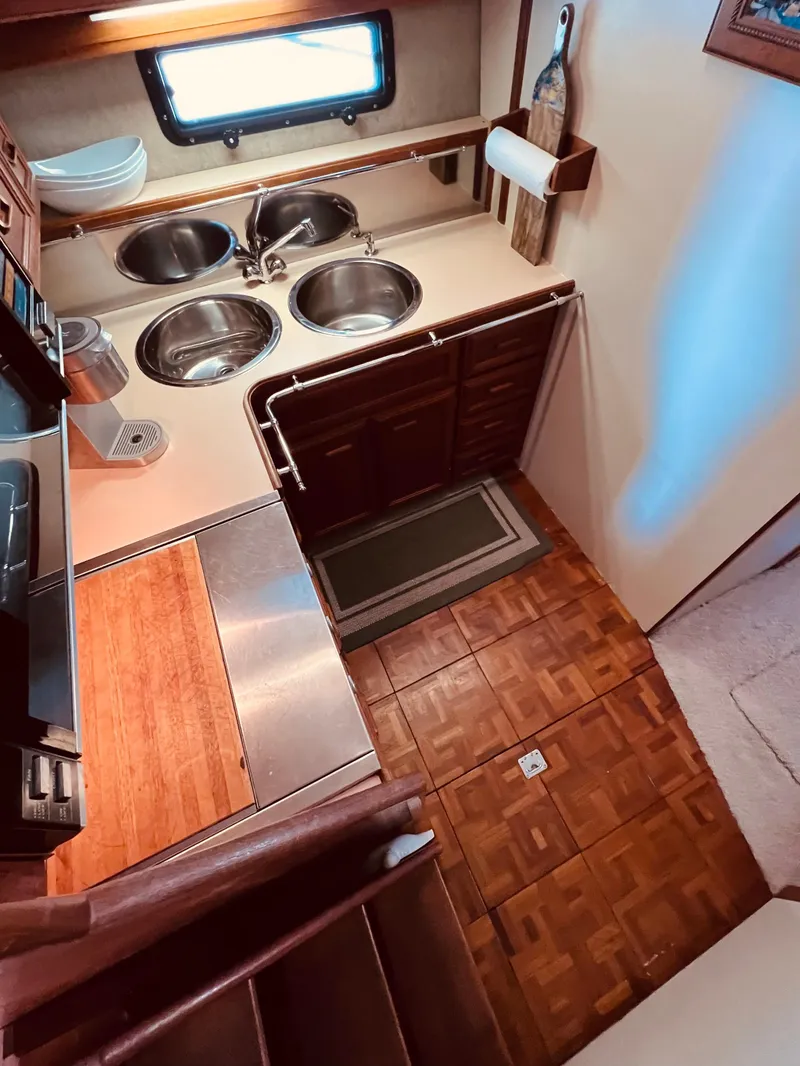 Slide: The Image of 1987 Carver 4227 Cockpit Motor Yacht kitchen with dual sinks and wooden flooring. - 21