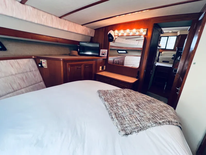 Slide: The Image of Luxurious interior of 1987 Carver 4227 Cockpit Motor Yacht with cozy bedroom setup. - 23