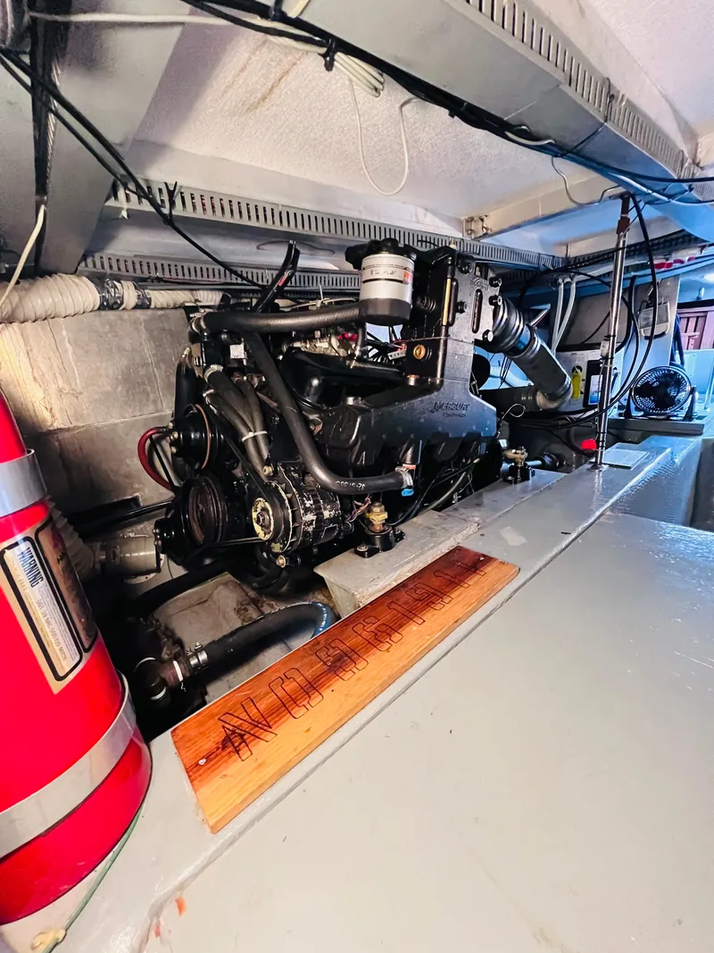 Slide: The Image of Engine room of 1987 Carver 4227 Cockpit Motor Yacht with visible machinery and fire extinguisher. - 30
