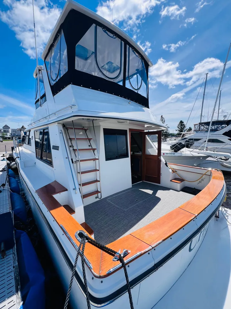 Slide: The Image of 1987 Carver 4227 Cockpit Motor Yacht docked under a clear blue sky. - 4