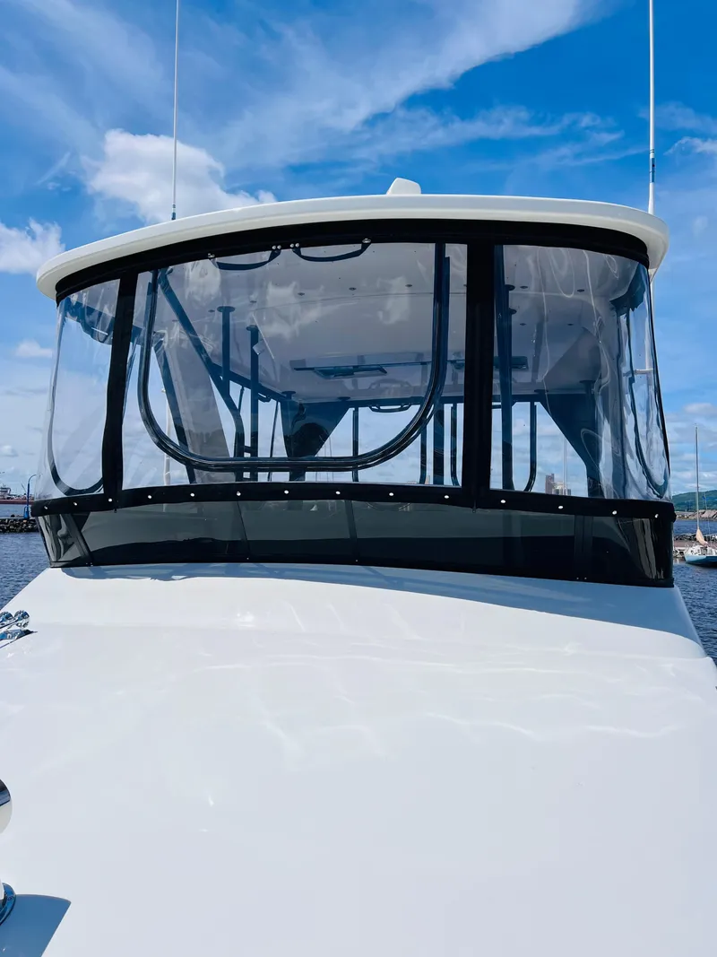 Slide: The Image of 1987 Carver 4227 Cockpit Motor Yacht with clear cockpit enclosure under blue sky. - 5