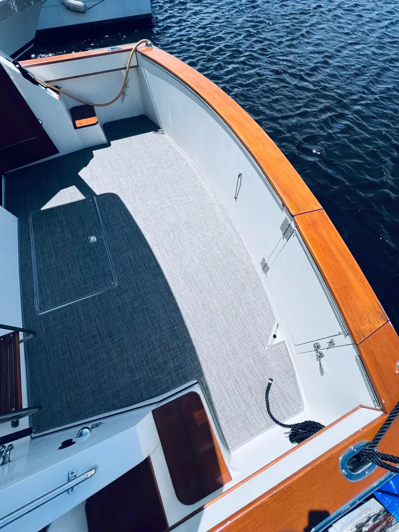 Slide: The Image of 1987 Carver 4227 Cockpit Motor Yacht with spacious deck and wooden trim, docked on water. - 6