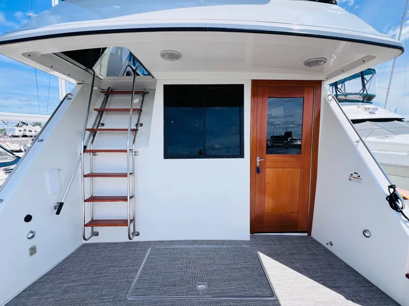 Slide: The Image of 1987 Carver 4227 Cockpit Motor Yacht with wooden door and ladder, docked at marina. - 7