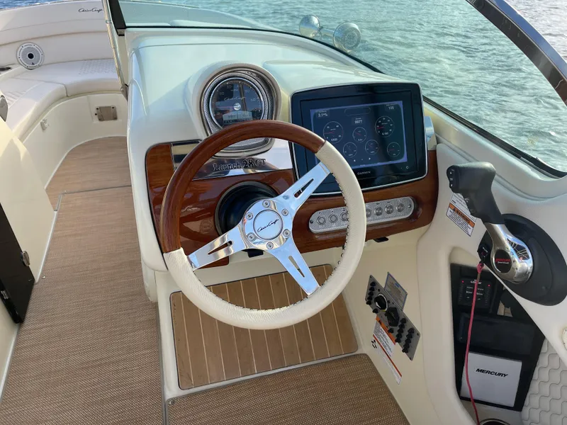 Slide: The Image of 2021 Chris-Craft 28 Launch GT boat dashboard with steering wheel and Garmin display. - 13