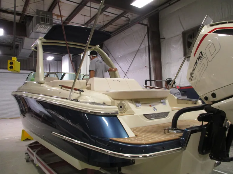Slide: The Image of 2021 Chris-Craft 28 LAUNCH GT boat in a warehouse, rear view with outboard motor. - 22
