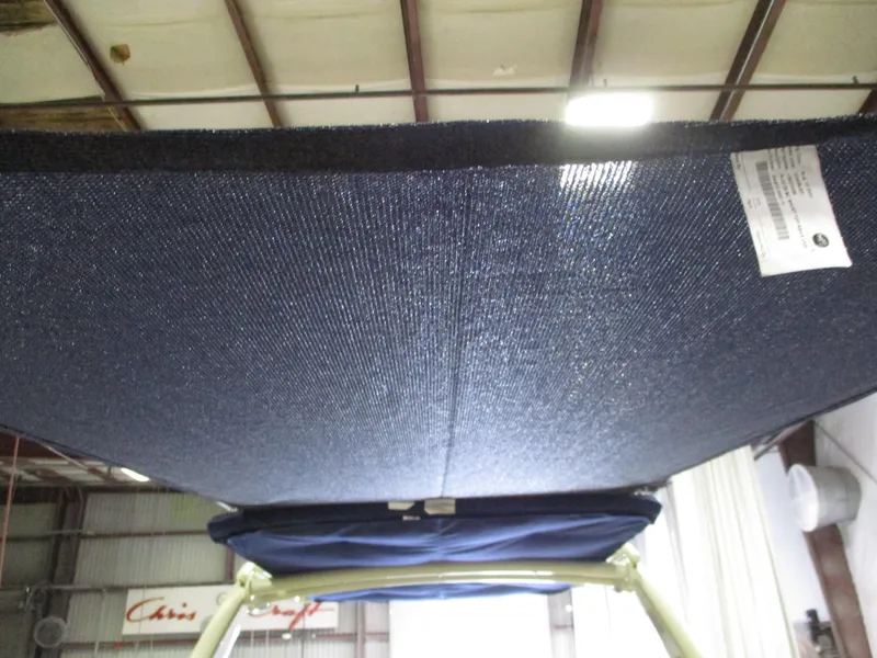 Slide: The Image of 2021 Chris-Craft 28 LAUNCH GT boat canopy under view in a warehouse. - 23