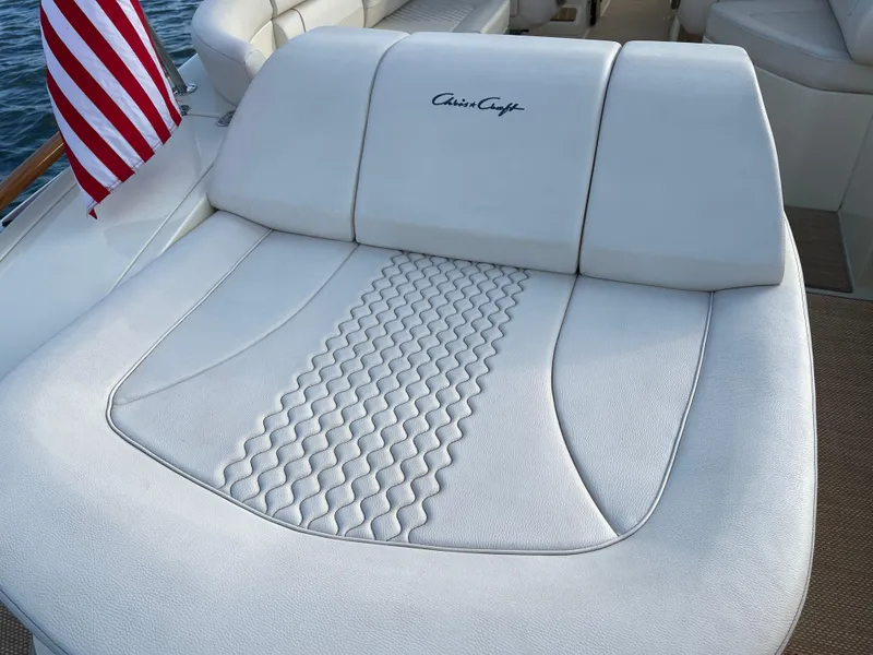 Slide: The Image of 2021 Chris-Craft 28 LAUNCH GT boat with white leather seating and American flag. - 26