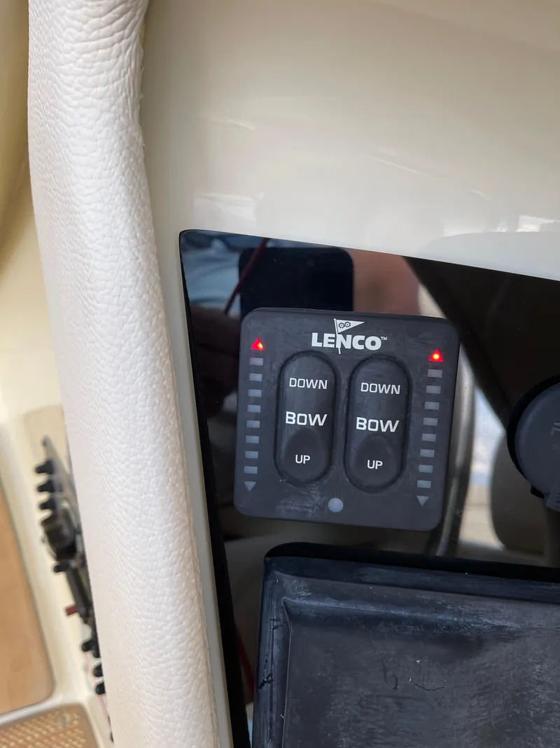 Slide: The Image of Lenco trim tab controls on 2021 Chris-Craft 28 Launch GT boat dashboard. - 27