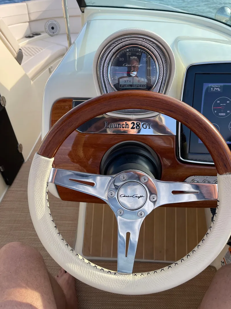 Slide: The Image of Chris-Craft 28 Launch GT 2021 boat dashboard with wooden steering wheel and speedometer. - 29