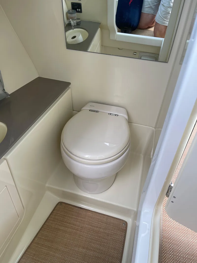 Slide: The Image of 2021 Chris-Craft 28 Launch GT boat bathroom with toilet, sink, and mirror. - 33