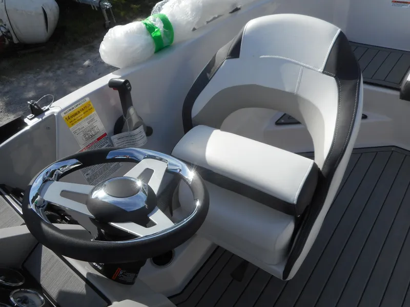 Slide: The Image of 2024 Starcraft SVX 210 OB DC boat cockpit with steering wheel and captain's chair. - 11