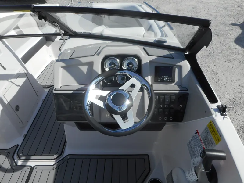 Slide: The Image of 2024 Starcraft SVX 210 OB DC boat dashboard and steering wheel. - 2