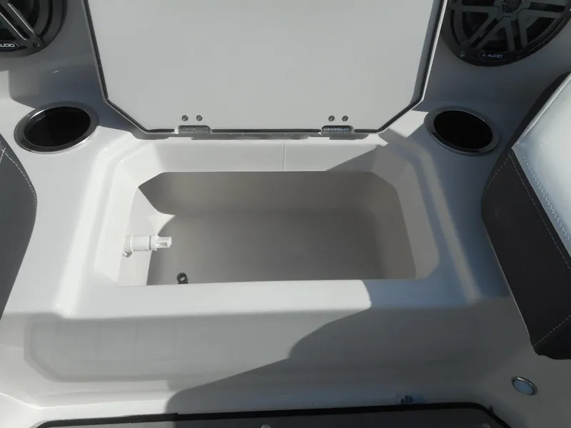 Slide: The Image of 2024 Starcraft SVX 210 OB DC boat storage compartment with cup holders and speakers. - 8