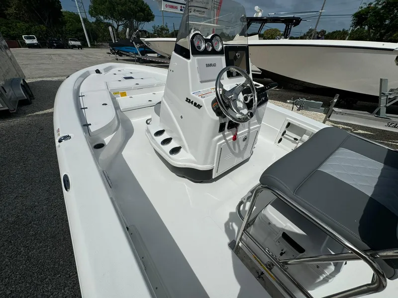 Slide: The Image of 2025 NauticStar 224 Bay boat interior with steering console and seating. - 13