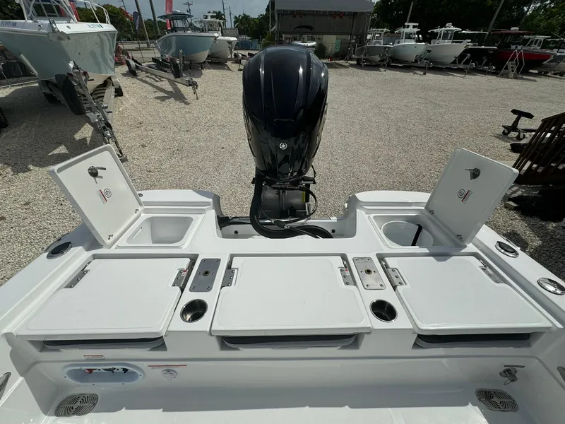 Slide: The Image of 2025 NauticStar 224 Bay boat with open storage compartments and outboard motor. - 15