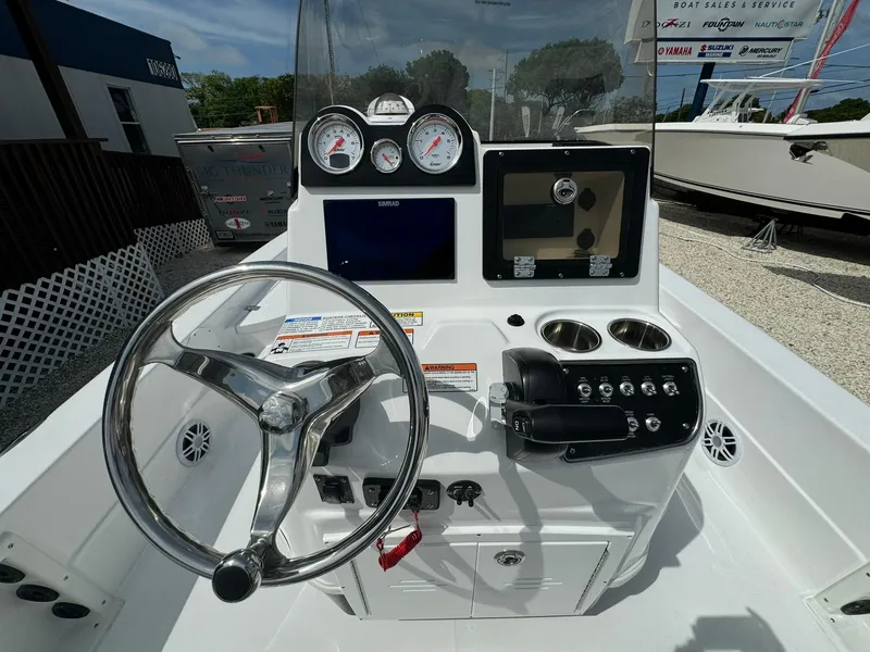 Slide: The Image of 2025 NauticStar 224 Bay boat console with steering wheel, gauges, and controls. - 2