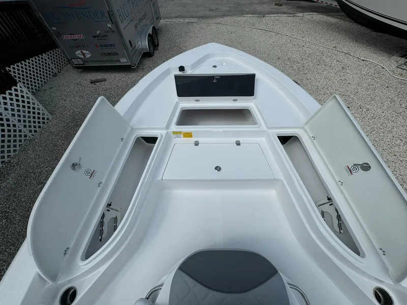 Slide: The Image of 2025 NauticStar 224 Bay boat with open storage compartments. - 4