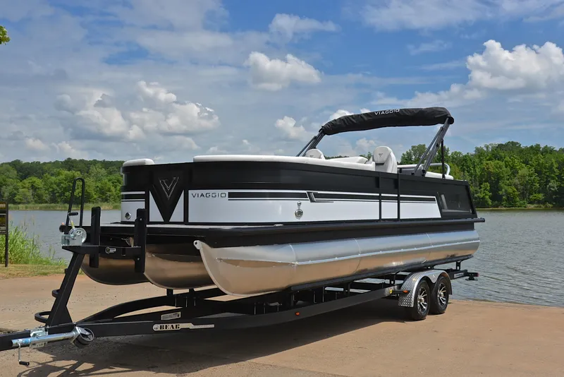 Slide: The Image of 2023 Viaggio Diamante 26 U Platinum pontoon boat on trailer by a lake. - 10