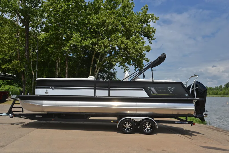 Slide: The Image of 2023 Viaggio Diamante 26 U Platinum pontoon boat on trailer by a lake. - 11