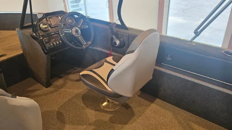 Slide: The Image of Interior of 2025 Starcraft FUSION 16 DC boat, featuring steering wheel and captain's chair. - 6