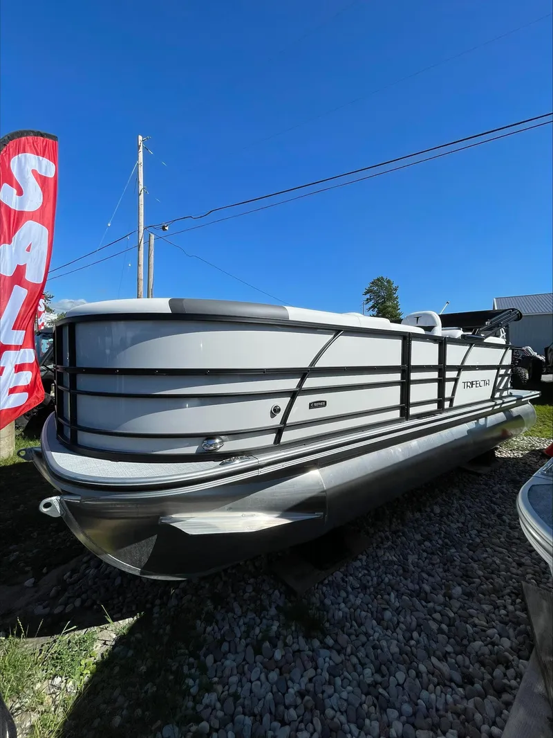 Slide: The Image of 2024 Trifecta 22RFCS pontoon boat for sale under clear blue sky. - 2
