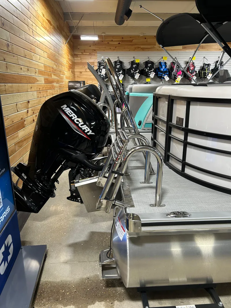 Slide: The Image of 2024 Trifecta 22RFCS pontoon boat with Mercury outboard motor in showroom. - 7