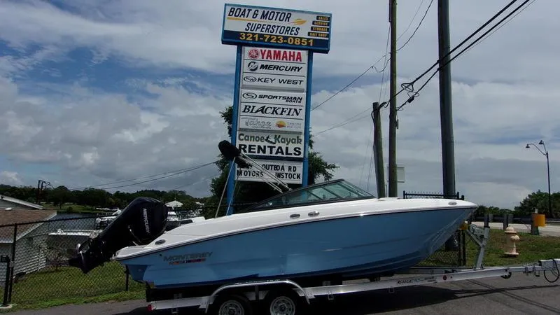 The Image of 2025 Monterey M 205 boat on trailer at dealership with signage in background. - 1