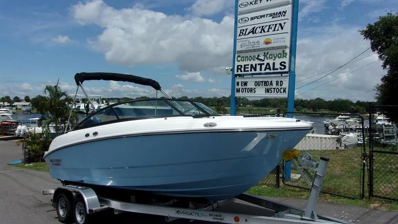 Slide: The Image of 2025 Monterey M 205 boat on trailer near rental sign, under blue sky. - 3