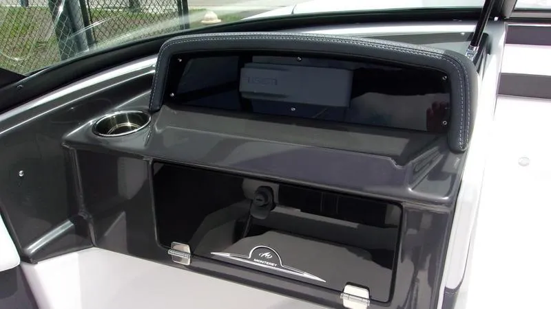 Slide: The Image of 2025 Monterey M 205 boat dashboard with storage compartment and cup holder. - 7