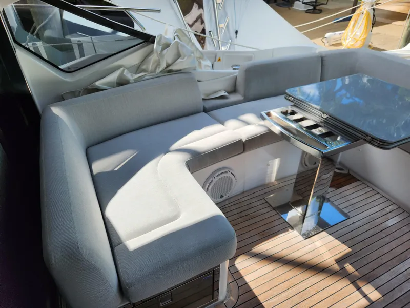 Slide: The Image of Luxurious seating area on 2019 Azimut S6 yacht with sleek table and wooden deck. - 29