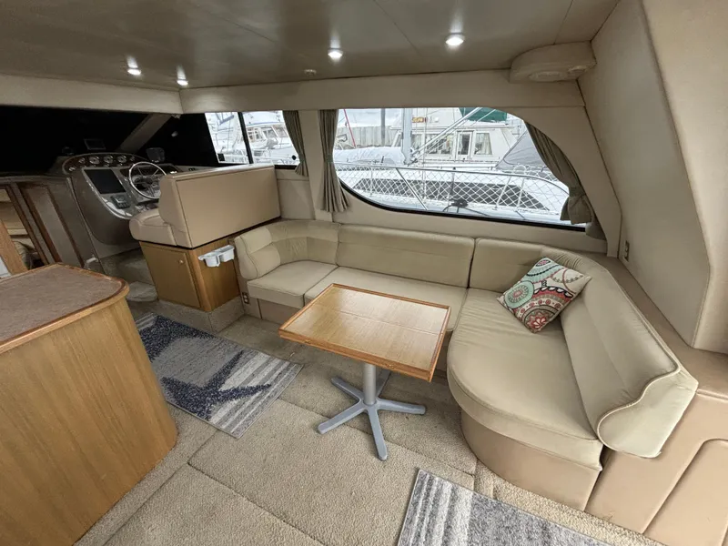Slide: The Image of Interior of 2000 Bayliner 3788 Command Bridge Motoryacht with beige seating and wooden table. - 16