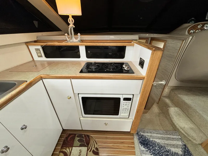 Slide: The Image of Compact kitchen area in a 2000 Bayliner 3788 Command Bridge Motoryacht with stove and microwave. - 18