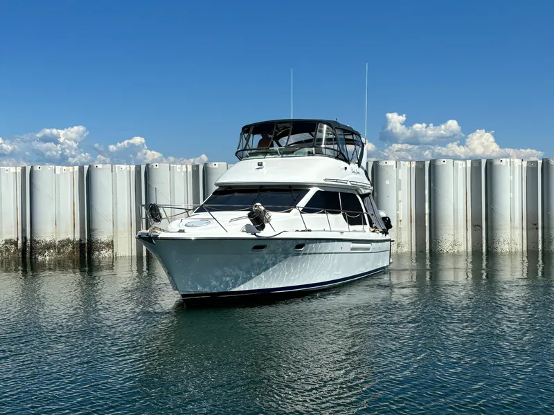 Slide: The Image of 2000 Bayliner 3788 Command Bridge Motoryacht on calm water with blue sky. - 2
