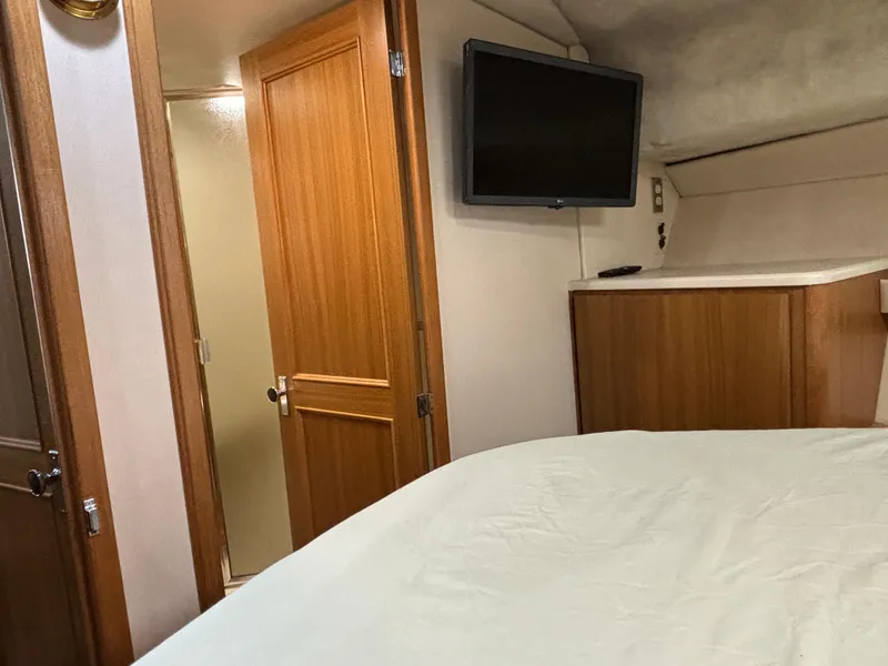 Slide: The Image of Bayliner 3788 Command Bridge Motoryacht 2000 interior cabin with TV and wooden door. - 22