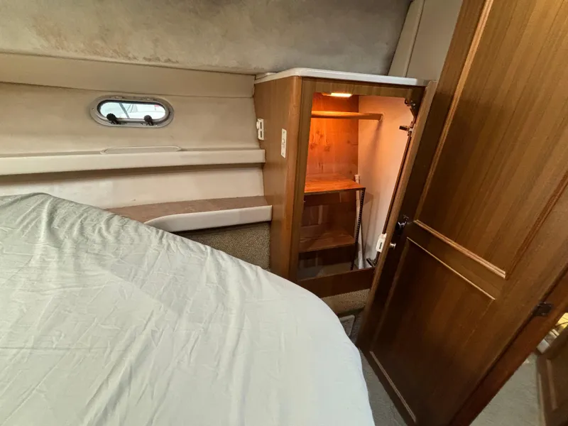 Slide: The Image of Bayliner 3788 Command Bridge Motoryacht 2000 interior cabin with bed and wooden closet. - 23
