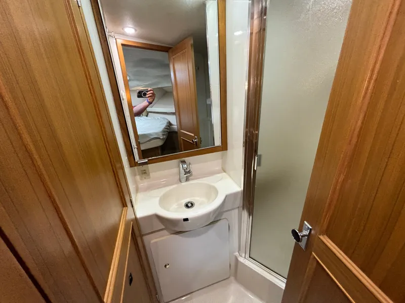 Slide: The Image of Compact bathroom in 2000 Bayliner 3788 Command Bridge Motoryacht with sink, mirror, and shower. - 24